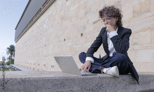 Bild auf Leinwand A student concentrating on her laptop on campus