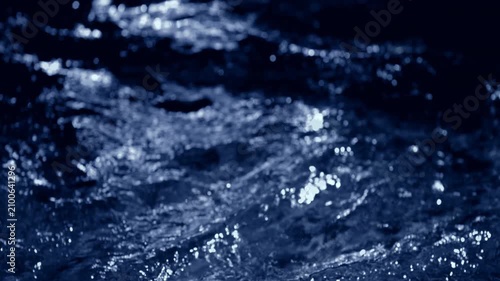 Fresh blue water macro background loop with splashing liquid on dark black backdrop. 3D animation wave fluid swirling backplate with copy space. Clean abstract bubbles texture.