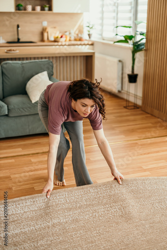 Принти на полотні Woman preparing to clean living room area rug