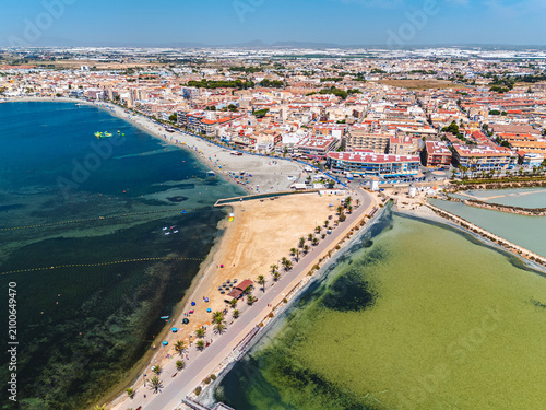 Aerial view of coastal town Salinas de San Pedro Lo Pagan sandy beaches, Mediterranean Sea water and salt lake in Spain. Mediterranean coast, vacation resort, travel
