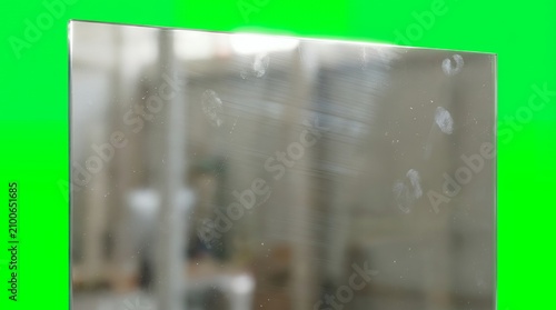 Rectangular Glass Surface With Fingerprint Smudges and Subtle Reflections Against a Solid Chroma Key Green Background
