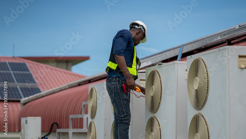 Professional engineers inspecting and checking the industrial air conditioning cooling system and HVAC units of a major facility or commercial building