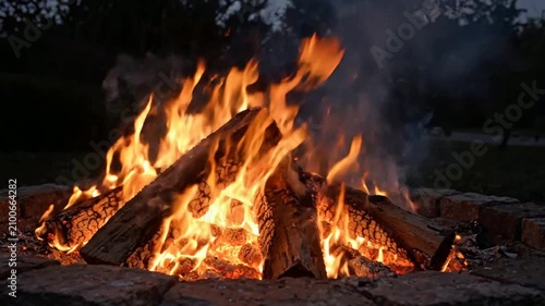 Campfire Flames Burning Brightly in Nighttime Outdoor Setting.