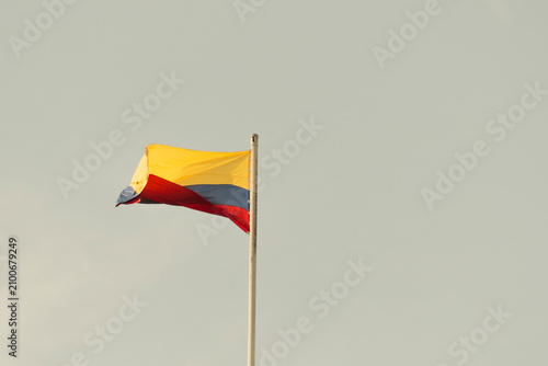 Foto Colombia flag waving in a blue cloudy sky