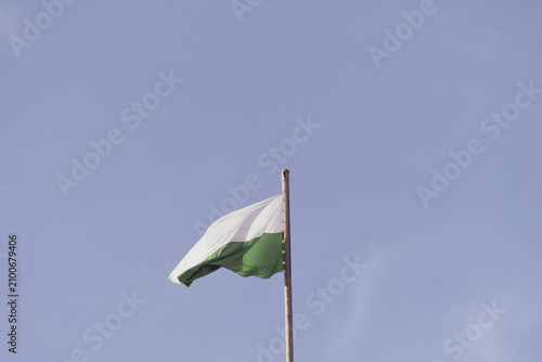Flag of Antioquia waving in a blue cloudy 