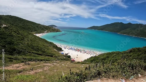 First-person walking footage approaching the scenic viewpoint of Pontal do Atalaia in Arraial do Cabo, Rio de Janeiro, Brazil with crystal-clear turquoise waters, tropical vegetation and breathtaking 