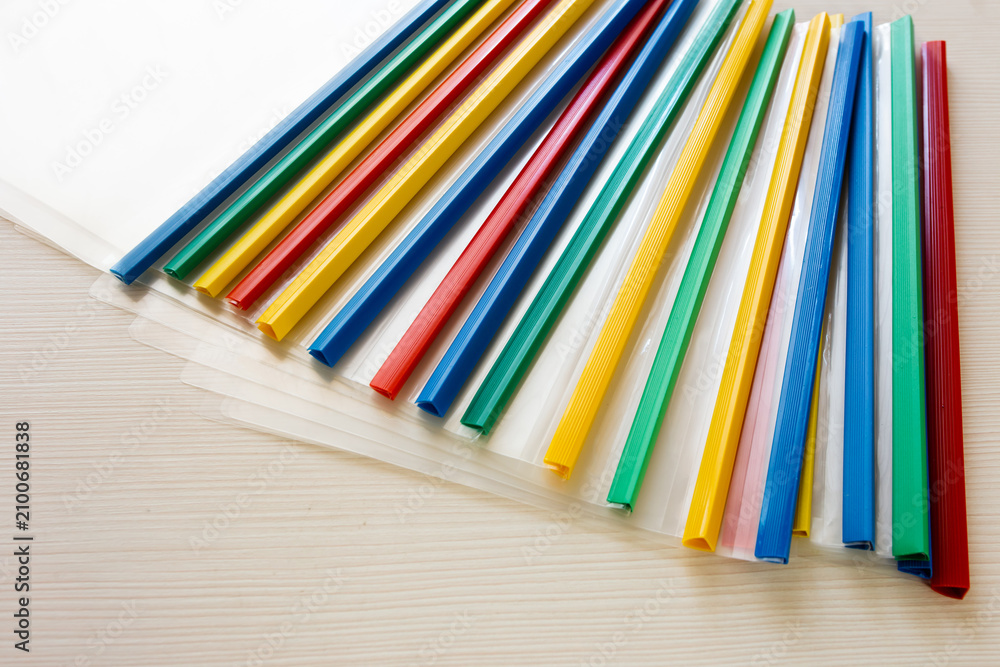 Obraz premium Colored plastic folders lie on the table.