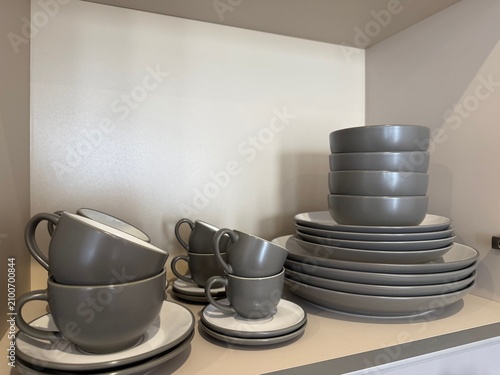 Obraz na płótnie Stacks of clean bowls, plates and cups in kitchen cabinet, closeup