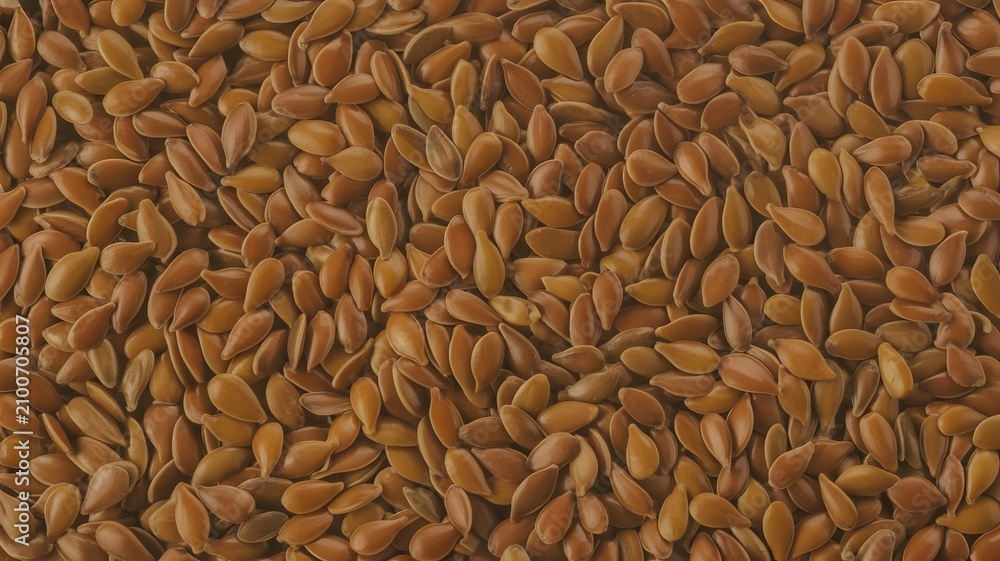Obraz premium Brown flax seeds filling the frame in a top view high resolution close up macro shot