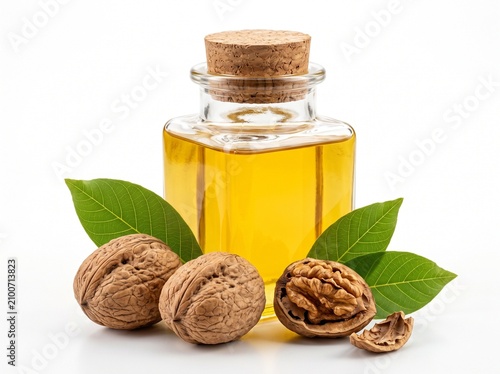 Fresh gourmet walnut oil in a square glass jar accompanied by textured walnut shells on a reflective white surface