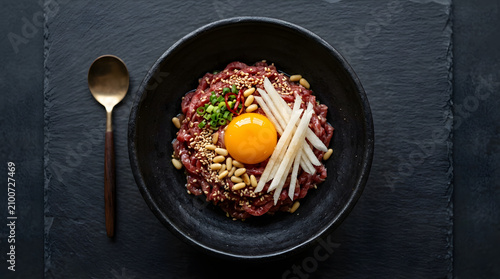 Korean yukhoe featuring finely sliced raw beef topped with glossy egg yolk