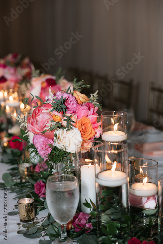 Elegant wedding reception table setting with glowing candles and floral centerpiece