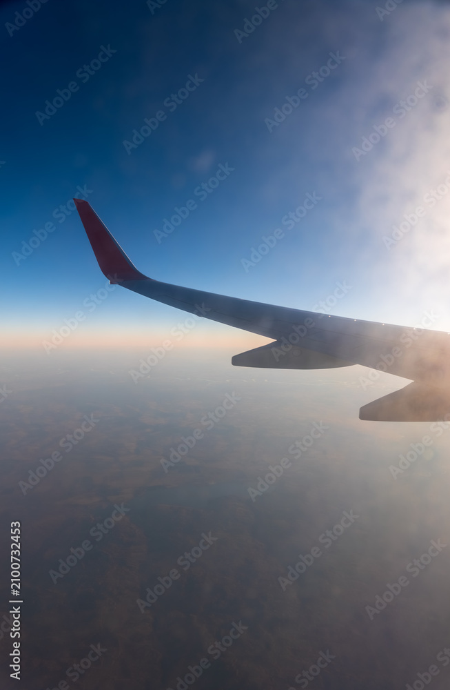 Fototapeta premium View on sunset and airplane wing from the inside