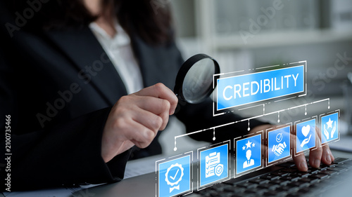 Canvas Print Business professional examining symbols of credibility with a magnifying glass in a modern office setting to signify trustworthiness and professional integrity