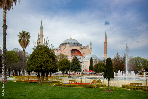 Obraz na płótnie The grand domes and minarets of Hagia Sophia rise above the green gardens and palm trees of Sultanahmet Square in Istanbul, Turkey, under a blue spring sky