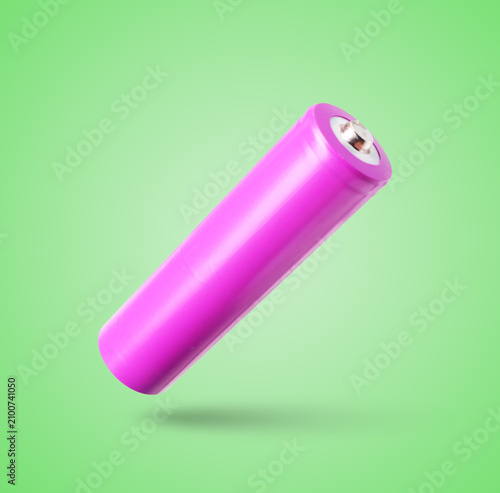 Foto Magenta alkaline battery in air on pastel green background