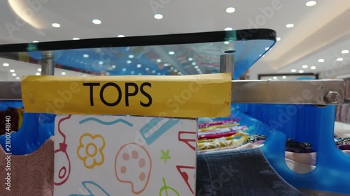 yellow_tops_label_on_clothing_rack_inside_a_fashion_retail_store