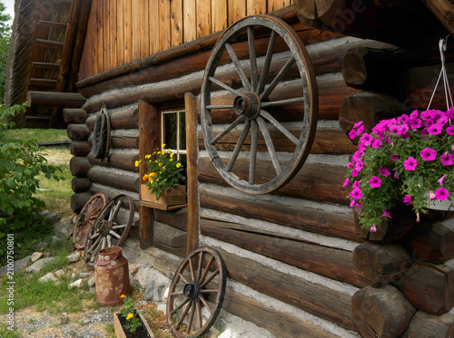 Wooden wheels hanging on the wall of an old house.