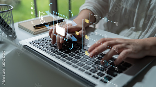Fotografie Professional woman typing on laptop with digital interface symbols showcasing data security, information flow, and technological innovation in modern workspace