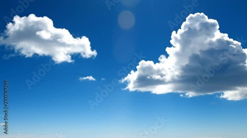 Bright blue sky background with fluffy white clouds and sunlight for natural outdoor summertime scenes.