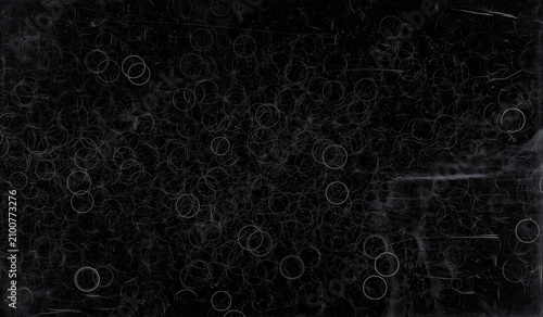 Black scratched metal surface with white circles and scratches  industrial background texture