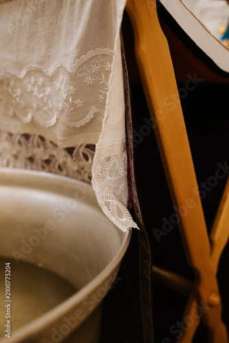 Schilderij op canvas the edge of a white lace towel by the baptismal font
