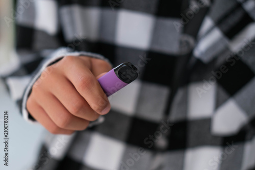 Disposable electronic cigarettes in a teenager's hands.