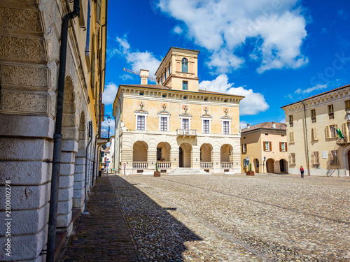 Sabbioneta. Italy. An Italian Renaissance town and UNESCO World Heritage site. Showcasing the historic Ducal Palace on a cobblestone plaza under a bright sky. Reflecting cultural heritage and tourism
