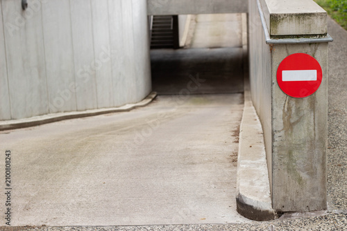 Konstfotografi Concrete ramp leading to a restricted access area marked by a red no entry sign,