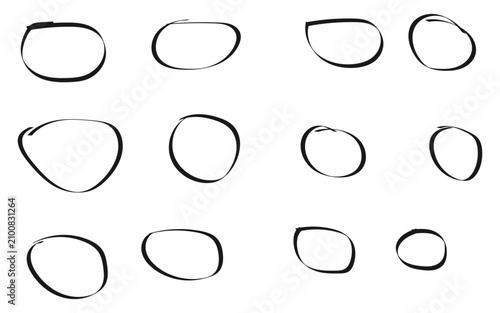 Set of twelve hand drawn black circles and oval shapes made with a marker pen on paper