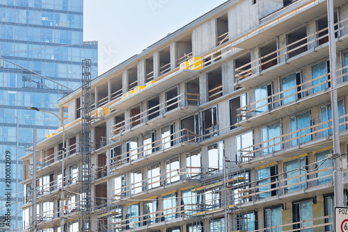 Canvas Print Modern residential building under construction with scaffolding and glass window