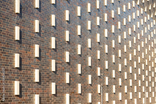 Bild auf Leinwand Textured brick wall with protruding white rectangular elements creating a unique
