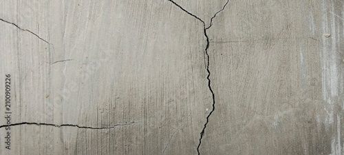 Deep cracks in gray concrete surface.