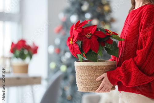 Woman in red sweater holdin...