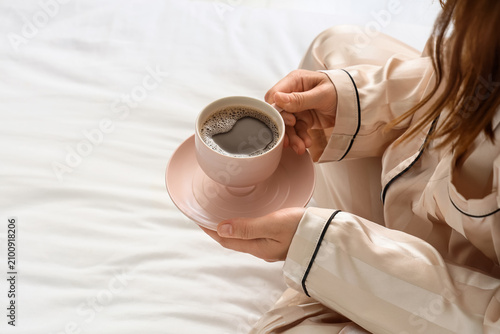 Woman in silk pajamas holdi...