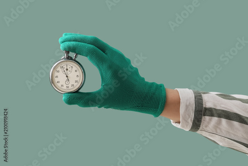 Hand in green glove holding...