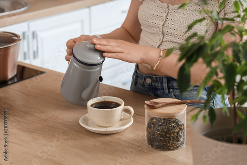Woman pouring coffee from a...
