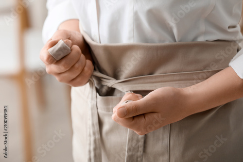 Person tying a beige apron ...