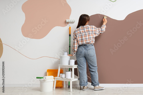 Young woman painting abstra...