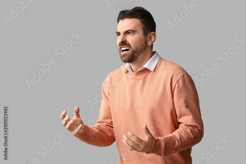 Angry male office worker on light background