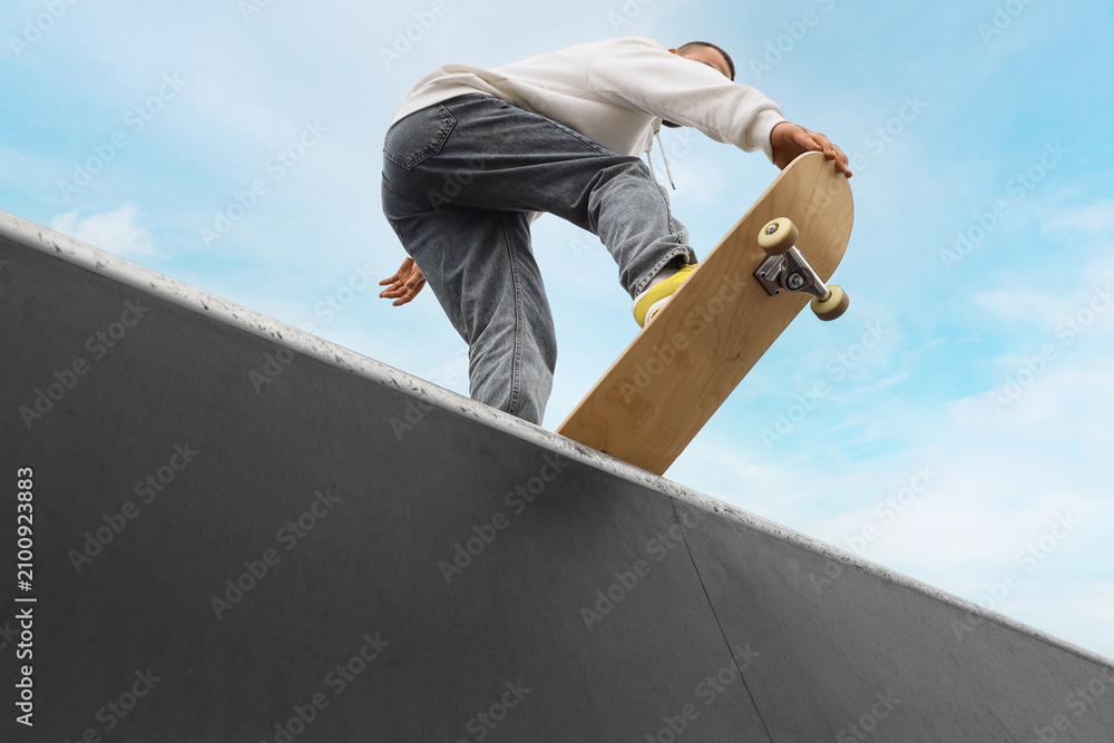 Obraz premium Young man with skateboard at skatepark