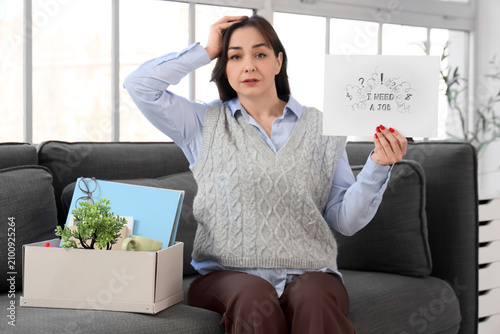 Fired businesswoman holding paper with text I NEED A JOB and personal stuff o...