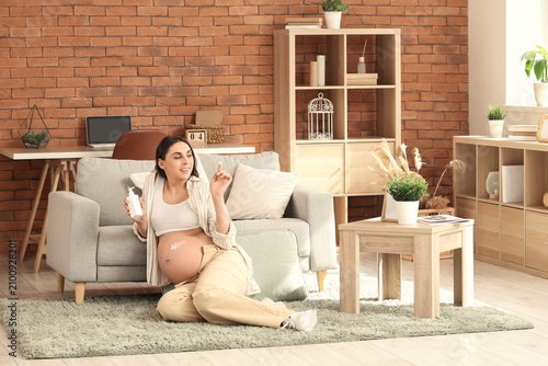 Young pregnant woman applyi...