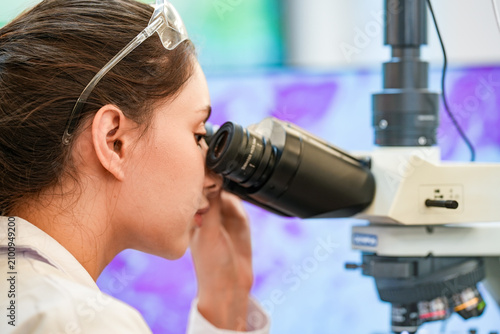 Картината върху платно Medical pathologist adjusting microscope eyepiece for cancer diagnosis