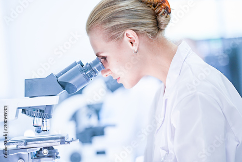 Foto Medical pathologist looking through microscope eyepiece for cancer diagnosis