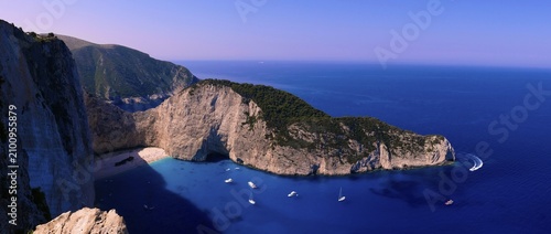 Paralia Navagio, Shipwreck Beach, panoramic photo, rocky cliff, shipwreck MV Panagiotis, excursion boats, blue and turquoise crystal clear sea, cloudless blue sky, Zakynthos, Ionian Islands, Greece