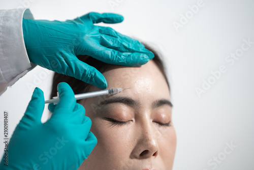 Cuadro en lienzo Close-up of a woman receiving a cosmetic injection in the forehead by gloved han