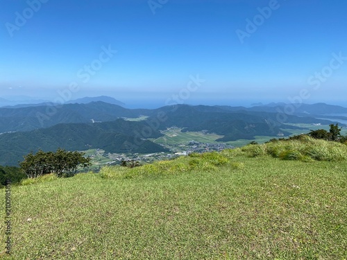 Mountain Valley Panorama with Green Fields and Blue Sky in Summer