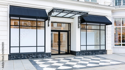 Elegant storefront with large display windows and black awnings on a white building facade