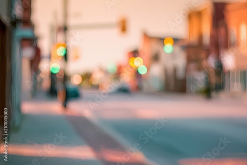 Soft focus street scene with blurred traffic lights and buildings in warm light